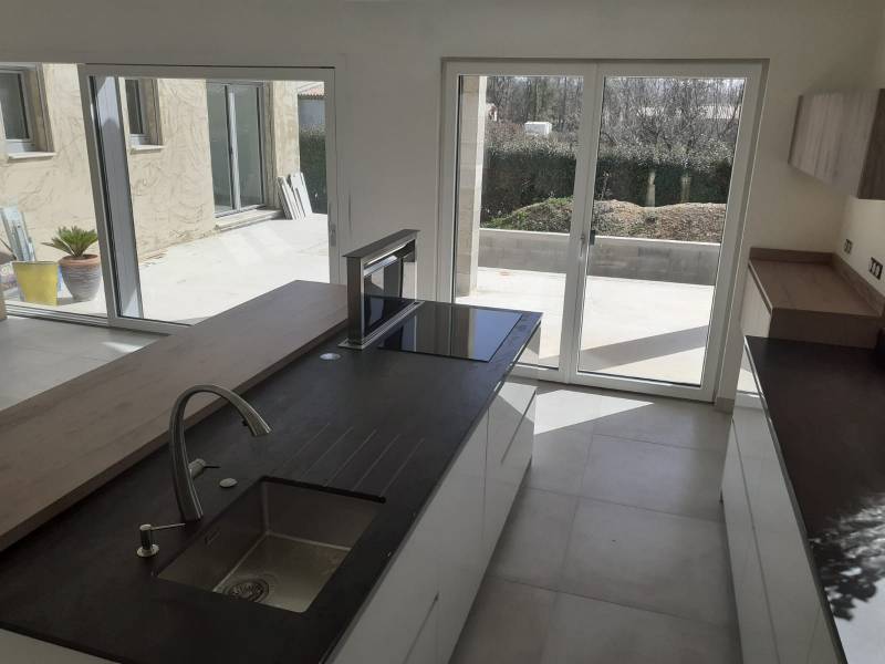Cuisine bois et blanc avec plan de travail Dekton et hotte de plan proche sur lunel 